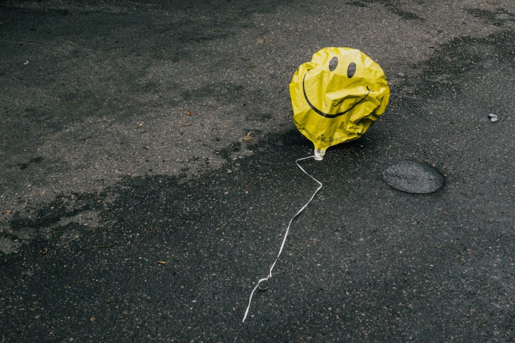 Einzelner Luftballon vor grauem Himmel